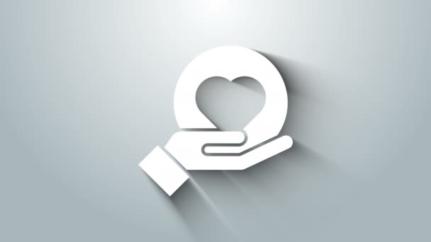 Corazón blanco en la mano icono aislado sobre fondo gris. Mano dando símbolo de amor. Animación gráfica de vídeo 4K — Vídeo de stock
