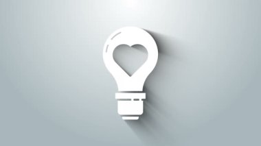 Gri arkaplanda izole edilmiş bir ampul ikonunda beyaz kalp şekli. Aşk sembolü. Sevgililer Günü sembolü. 4K Video hareketli grafik canlandırması