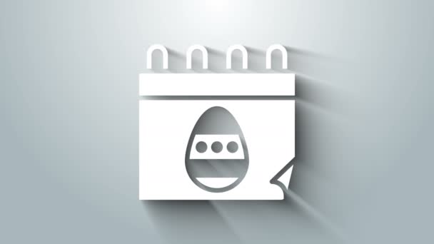 Белый календарь с иконкой пасхального яйца изолирован на сером фоне. Символ весеннего христианства. Видеографическая анимация 4K — стоковое видео
