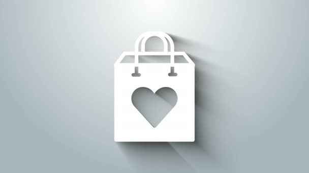 グレーの背景にハートアイコンを隔離したホワイトショッピングバッグ。ショッピングバッグ店はハートアイコンのような愛。バレンタインデーのシンボル。4Kビデオモーショングラフィックアニメーション — ストック動画