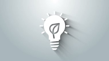 Gri arkaplanda yaprak simgesi olan beyaz ampul. Çevre enerjisi kavramı. Alternatif enerji kavramı. 4K Video hareketli grafik canlandırması