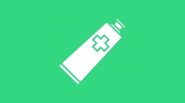 Yeşil zemin üzerinde beyaz merhem krem tüp tıp ikonu izole. Tüp, kap, diş macunu, krem rengi. 4K Video hareketli grafik canlandırması