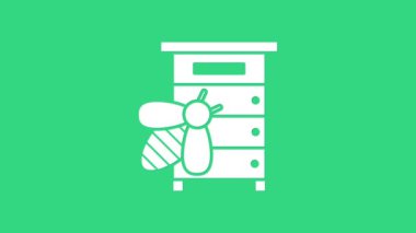 Yeşil arka planda izole edilmiş arılar için beyaz kovan. Arı kovanı sembolü. Apiary ve arı yetiştiriciliği. Tatlı doğal yemek. 4K Video hareketli grafik canlandırması