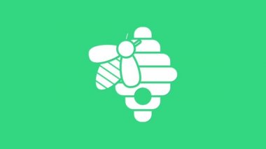 Yeşil arka planda izole edilmiş arılar için beyaz kovan. Arı kovanı sembolü. Apiary ve arı yetiştiriciliği. Tatlı doğal yemek. 4K Video hareketli grafik canlandırması