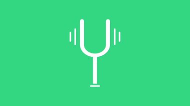 Müzik aletlerini ayarlamak için beyaz müzik ayarlama çatalı yeşil arka planda izole edilmiş. 4K Video hareketli grafik canlandırması