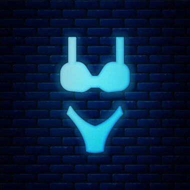 Glowing neon Summer beach swimsuit icon isolated on brick wall background. Beach women fashion. Vector