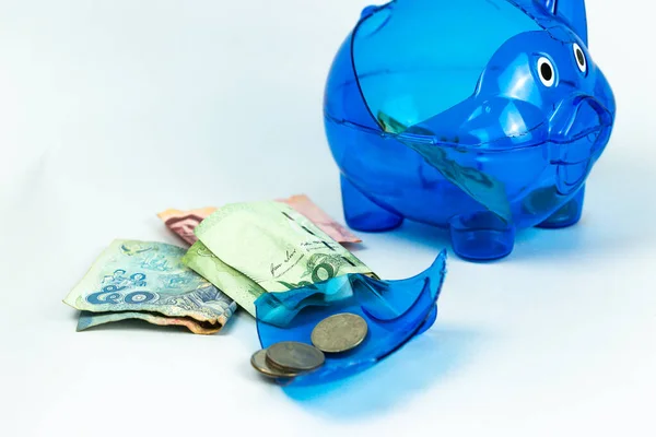 A broken blue piggy bank from a virus crisis. Money-saving plan failure signal. isolated background money and piggy bank close-up photography.