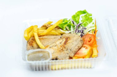 Beyaz arka planda biftek ve salata. Plastik tepsi ya da köpükle eve servis edildiğinden beri yeni normaller. Sağlıklı beslenmek için Keto. izole edilmiş arkaplan fotoğrafçılığını kapat.