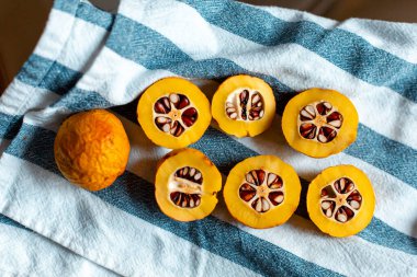 Mavi çizgili havluyla tohumlu turuncu Japon ayvası.