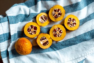 Mavi çizgili havluyla tohumlu turuncu Japon ayvası.