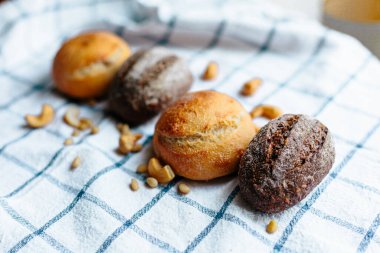 Masanın üzerinde mavi ve beyaz masa örtüsü olan haşhaş tohumlu çörekler. Asgari stil kavramsal natürmort fotoğrafçılık.