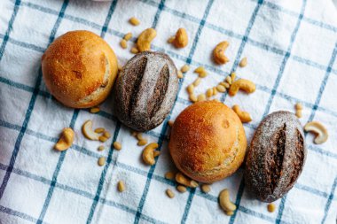 Masanın üzerinde mavi ve beyaz masa örtüsü olan haşhaş tohumlu çörekler. Asgari stil kavramsal natürmort fotoğrafçılık.