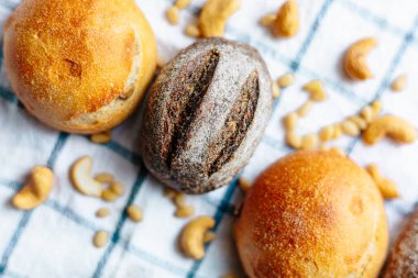 Masanın üzerinde mavi ve beyaz masa örtüsü olan haşhaş tohumlu çörekler. Asgari stil kavramsal natürmort fotoğrafçılık.