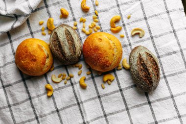 Masanın üzerinde mavi ve beyaz masa örtüsü olan haşhaş tohumlu çörekler. Asgari stil kavramsal natürmort fotoğrafçılık.