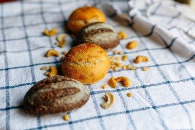 Masanın üzerinde mavi ve beyaz masa örtüsü olan haşhaş tohumlu çörekler. Asgari stil kavramsal natürmort fotoğrafçılık.