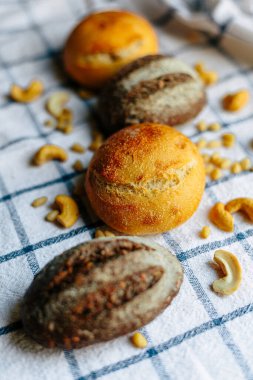 Masanın üzerinde mavi ve beyaz masa örtüsü olan haşhaş tohumlu çörekler. Asgari stil kavramsal natürmort fotoğrafçılık.
