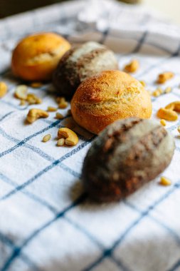 Masanın üzerinde mavi ve beyaz masa örtüsü olan haşhaş tohumlu çörekler. Asgari stil kavramsal natürmort fotoğrafçılık.