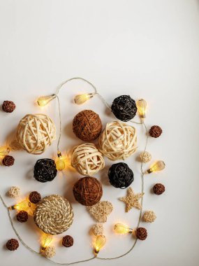 Beyaz ahşap arka planda kar taneleri ve ladin dallarıyla Noel sınırı. Masanın üstünde süslemeler ve süslemelerle süslenmiş üst manzara