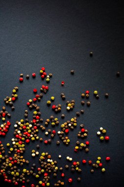 koyu arkaplanda kırmızı siyah beyaz ve yeşil biber