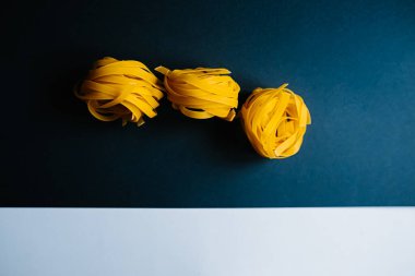 Koyu mavi arka planda İtalyan makarna tagliatelle.
