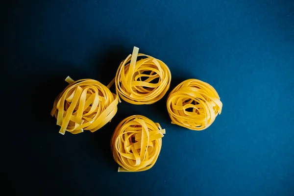 Italiensk Pasta Tagliatelle Mörkblå Bakgrund — Stockfoto