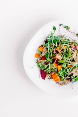 Sebzeli taze organik salata ve beyaz arka planda tohumlar.