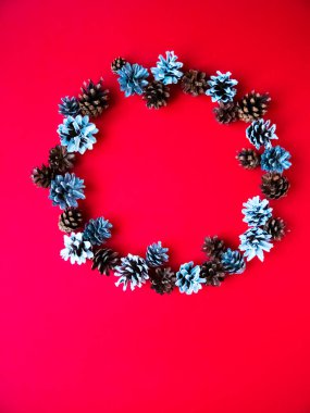 Kırmızı arka planda ren geyiği olan yaratıcı bir Noel çelengi. Yeni yıl afişi. Üst görünüm.