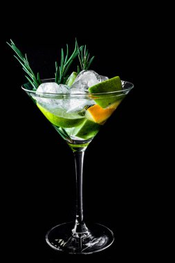 Coctail with orange juce and champagne, lime and lemon on dark background. New Year or Birthday party. Vertical. Copy space.