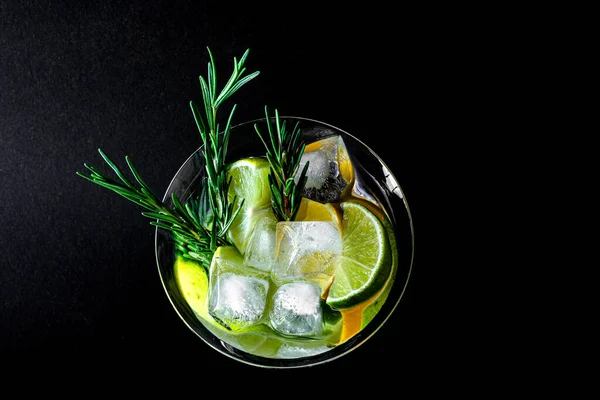 Coctail with orange juce and champagne, lime and lemon on dark background. New Year or Birthday party. Vertical. Copy space.