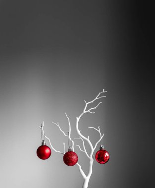 Kırmızı Noel topları beyaz dalda, açık ve koyu arkaplanda. Bir fincanda kırmızı Noel topları. Noel süslemeli Mutlu Noeller kartı. 