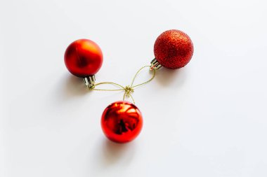 Kırmızı Noel topları beyaz dalda, açık ve koyu arkaplanda. Bir fincanda kırmızı Noel topları. Noel süslemeli Mutlu Noeller kartı. 