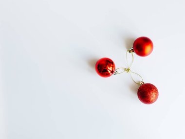 Kırmızı Noel topları beyaz dalda, açık ve koyu arkaplanda. Bir fincanda kırmızı Noel topları. Noel süslemeli Mutlu Noeller kartı. 