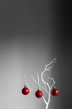 Kırmızı Noel topları beyaz dalda, açık ve koyu arkaplanda. Bir fincanda kırmızı Noel topları. Noel süslemeli Mutlu Noeller kartı. 