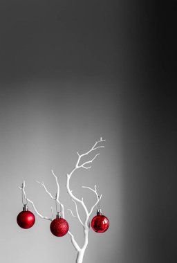 Kırmızı Noel topları beyaz dalda, açık ve koyu arkaplanda. Bir fincanda kırmızı Noel topları. Noel süslemeli Mutlu Noeller kartı. 