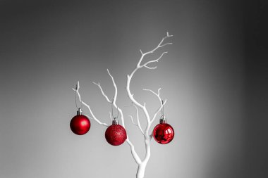 Kırmızı Noel topları beyaz dalda, açık ve koyu arkaplanda. Bir fincanda kırmızı Noel topları. Noel süslemeli Mutlu Noeller kartı. 