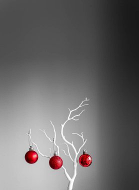 Kırmızı Noel topları beyaz dalda, açık ve koyu arkaplanda. Bir fincanda kırmızı Noel topları. Noel süslemeli Mutlu Noeller kartı. 