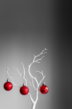 Kırmızı Noel topları beyaz dalda, açık ve koyu arkaplanda. Bir fincanda kırmızı Noel topları. Noel süslemeli Mutlu Noeller kartı. 