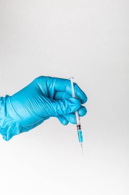 Mavi eldivenli tıbbi eller şırınga ve aşı taşıyor. COVID-19 Coronavirus Aşısı ve Şırınga Konsepti Görüntüsü. Sağlık teşhisi ve terapi için tıp doktorunun elindeki aşı şırıngası..