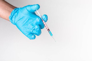 Mavi eldivenli tıbbi eller şırınga ve aşı taşıyor. COVID-19 Coronavirus Aşısı ve Şırınga Konsepti Görüntüsü. Sağlık teşhisi ve terapi için tıp doktorunun elindeki aşı şırıngası..