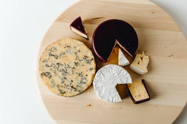 Koyu ve beyaz arka planda farklı peynir çeşitleri. Farklı lezzetli peynirlerden, yakın plan. Peynir çeşitleri. Çeşitli peynir çeşitleri. Uzayı kopyala Peynir Koleksiyonu. 