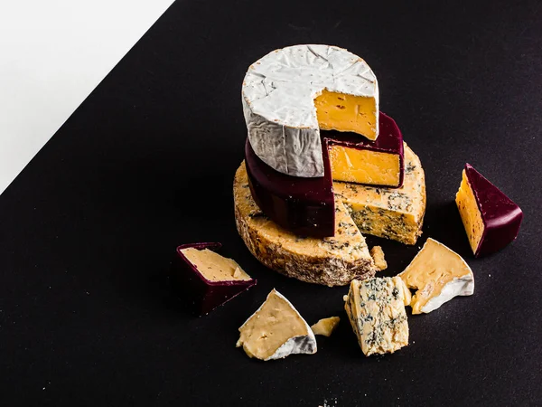 Assortment of different cheese types on dark and white background. Different types of delicious cheese, closeup. Variety of cheese. Various types of cheese. Copy space. Cheese Collection.