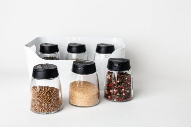 Tuz ve biber öğütücüleri. Kurumuş kara biber tohumu ve beyaz deniz tuzu yukarıdan görünen beyaz bir arka planda izole edilmiş.. 