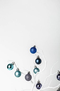 Noel süsü. Beyaz bir brunch 'ta mavi ve naneli noel baloları. Beyaz arka plan. Noel ve Yeni Yıl tatili geçmişi. Renkli mavi ve dallarda naneli toplar. Şenlikli kış tatili. 