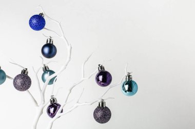 Noel süsü. Beyaz bir brunch 'ta mavi ve naneli noel baloları. Beyaz arka plan. Noel ve Yeni Yıl tatili geçmişi. Renkli mavi ve dallarda naneli toplar. Şenlikli kış tatili. 