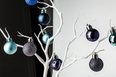 Noel süsü. Beyaz bir brunch 'ta mavi ve naneli noel baloları. Beyaz arka plan. Noel ve Yeni Yıl tatili geçmişi. Renkli mavi ve dallarda naneli toplar. Şenlikli kış tatili. 