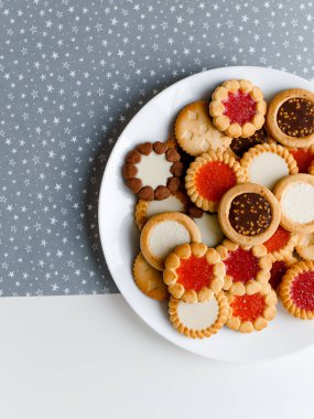 Farklı bisküviler, tatlılar ve kurabiye çerçevesi karışımı. Beyaz ahşap zemin üzerinde fotokopi alanı olan bir masa manzarası. Tatil pişirme konsepti. Kurabiyelerin arka planı çeşitlendirilmiş yakın plan