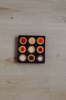 Farklı bisküviler, tatlılar ve kurabiye çerçevesi karışımı. Beyaz ahşap zemin üzerinde fotokopi alanı olan bir masa manzarası. Tatil pişirme konsepti. Kurabiyelerin arka planı çeşitlendirilmiş yakın plan