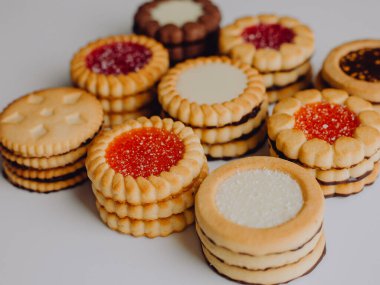 Farklı bisküviler, tatlılar ve kurabiye çerçevesi karışımı. Beyaz ahşap zemin üzerinde fotokopi alanı olan bir masa manzarası. Tatil pişirme konsepti. Kurabiyelerin arka planı çeşitlendirilmiş yakın plan