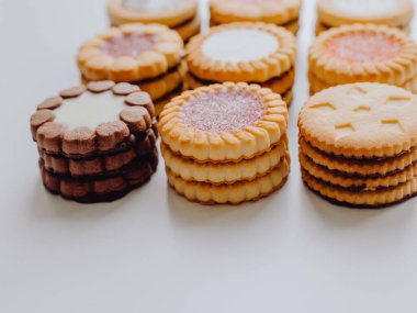 Farklı bisküviler, tatlılar ve kurabiye çerçevesi karışımı. Beyaz ahşap zemin üzerinde fotokopi alanı olan bir masa manzarası. Tatil pişirme konsepti. Kurabiyelerin arka planı çeşitlendirilmiş yakın plan