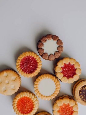Farklı bisküviler, tatlılar ve kurabiye çerçevesi karışımı. Beyaz ahşap zemin üzerinde fotokopi alanı olan bir masa manzarası. Tatil pişirme konsepti. Kurabiyelerin arka planı çeşitlendirilmiş yakın plan